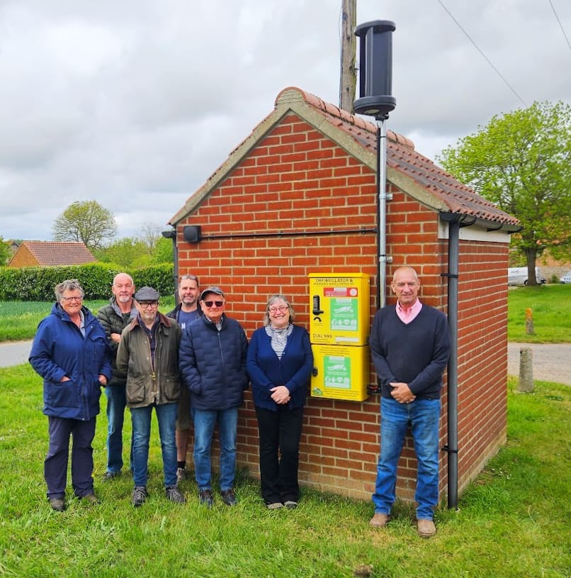 Suffield Parish Councillors with the bespoke off-grid lifesaving bus shelter in Suffield Green, Norfolk, UK